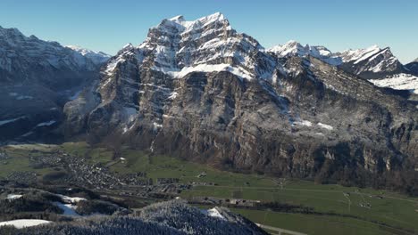 Fronalpstock-Glarus-Switzerland-village-in-green-valley-at-base-of-amazing-Alps-view