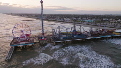 Galveston-Island-Historic-Pleasure-Pier,-sunny-evening-in-USA---Aerial-view