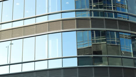 Modern-walls-are-made-of-glass-and-steel-with-reflections-of-buildings-and-blue-sky