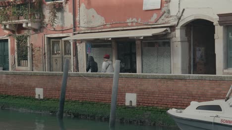 Das-Tägliche-Leben-In-Venedig-An-Einem-Ruhigen-Kanal,-Kamerafahrt-Vorbeikommender-Einheimischer