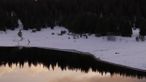 Aerial-pan-up-Of-Palù-Lake-In-Winter-Season-At-Sunset,-Valmalenco,-Itlay