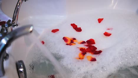 Moderne-Badewanne-Füllt-Sich-Mit-Wasser,-Rosenblätter-Schwimmen-Im-Wasser