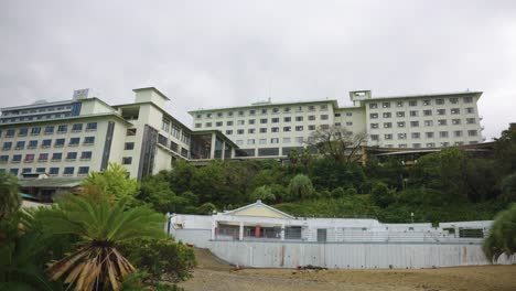 Hotel-Resort-Cerrado-Y-Abandonado-A-Orillas-Del-Mar,-Día-Oscuro-Y-Nublado-Estableciendo-Toma