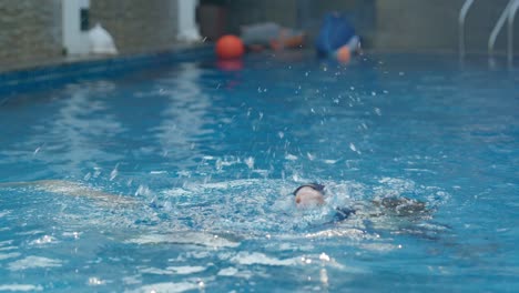 Close-up-of-arm-waving-underwater-at-a-swimming-pool