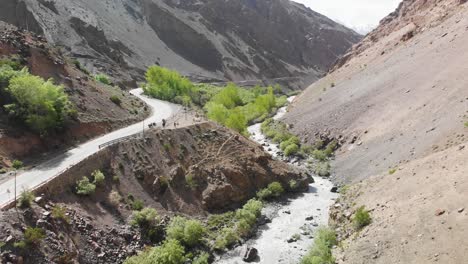 Road-and-river-crossing-thought-the-dry-mountains-in-Ladakh,-INDIA