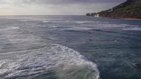 Imágenes-Aéreas-De-Las-Olas-Del-Océano-Y-Practicantes-De-Cometas-Mientras-Se-Dirigen-Al-Faro-De-Diamond-Head-En-El-Acantilado-Rocoso-De-La-Isla-De-Oahu,-Hawaii.