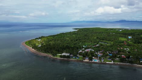 Overhead-aerial-view-of-lush-tropical-island-coast-with-quaint-village-and-turquoise-ocean-waters-in-Agojo,-San-Andres,-Catanduanes