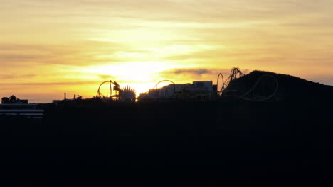 Colorful-sunset-at-dusk-in-the-background-of-an-Amusement-park