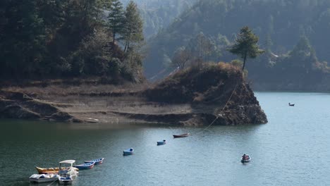 A-high-angle-view-of-a-small-paddle-boat-on-the-Kulekhani-Lake-in-Nepal-taking-tourists-on-a-tour-of-the-lake