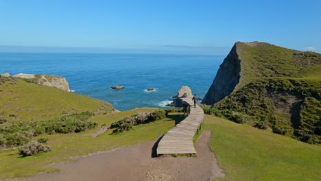 Panorama-Überflug-Einer-Person,-Die-Auf-Dem-Pier-Der-Seelen-In-Cucao,-Chiloé,-Spaziert