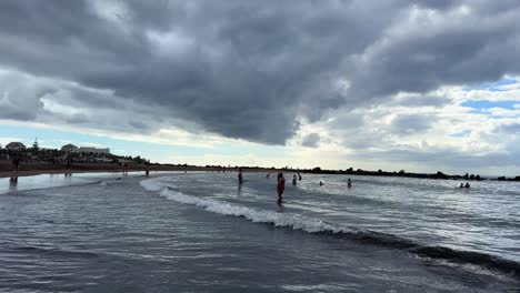 Sea-Tenerife-beach-ocean-water-retracting,-tourist-enjoy-nature-waves-clouds