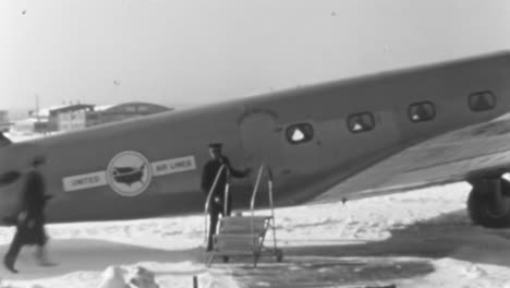 Passenger-Wearing-a-Suit-and-Hat-Hurries-to-Board-an-Airplane-in-the-1930s