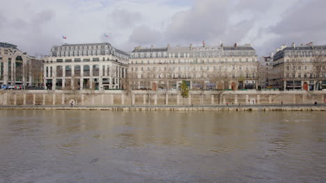 Breites,-Handgeführtes-Statisches-Filmmaterial-Von-Joggern,-Die-Im-Winter-Auf-Dem-Bürgersteig-Neben-Der-Seine-In-Paris,-Frankreich,-Laufen