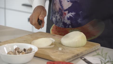 Slicing-a-big-white-onion-and-adding-pieces-to-food-processor-to-make-a-raw-vegan-burger-recipe