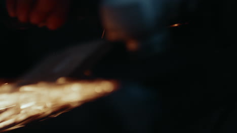 Close-up-slowmo-shot-of-angle-grinder-with-sparks-flying-off-screen