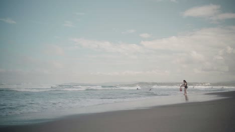 Frau-Steht-An-Einem-Strand-Und-Schaut-Auf-Die-Wellen-Des-Ozeans,-La-Union,-Philippinen