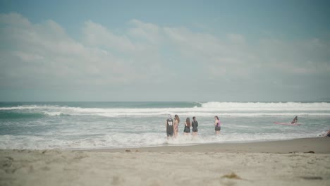 Group-of-Friends-Standing-the-Ocean-Waves-at-La-Union-Beach-in-the-Philippines