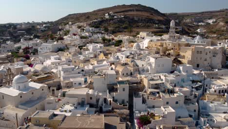 Orbital-View-over-Emporio-Village-with-Castle-and-Bell-Tower,-Santorini,-Greece