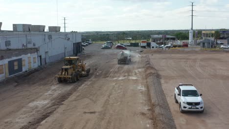 Workers-using-heavy-machinery-to-level-the-ground-for-parking-lot-construction
