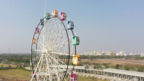 rajkot-atal-lake-drone-view-camera-is-moving-towards-the-side-there-is-a-big-work-giant-wheel-is-going-on,-Rajkot-New-Race-Course,-Atal-Sarovar
