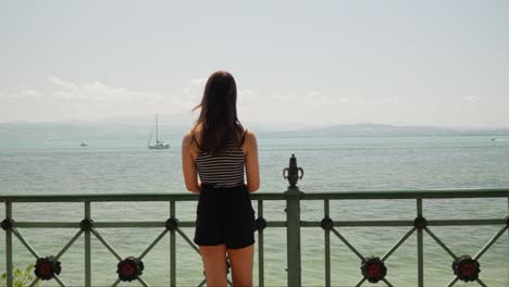 Woman-Walks-Up-to-Pier-to-Overlook-Lake-Constance-Bodensee-in-Friedrichshafen,-Germany