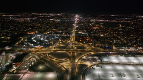 Denver-downtown-Colfax-i25-highway-cars-traffic-aerial-drone-snowy-winter-evening-dark-night-city-lights-landscape-skyscraper-Colorado-cinematic-anamorphic-pan-down-forward-motion