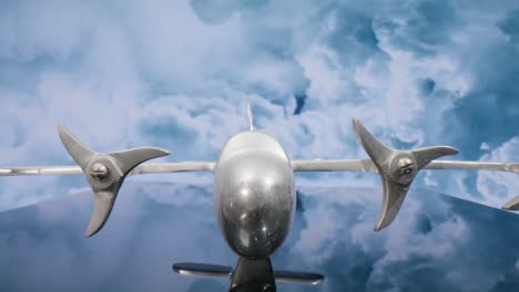 Macro-lens-view-of-silver-model-airplane-with-clouds-in-the-background-and-video-moving-in