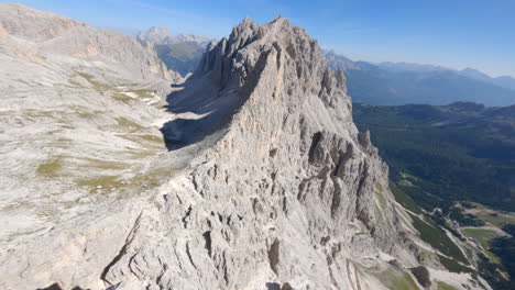 Dolomites-in-Italy,-aerial-FPV-drone-flying-above-ridge-on-sunny-day