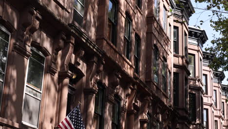 Panorama-Eines-Brownstone-Stadthauses-Aus-Rotem-Backstein-In-Brooklyn-Mit-Einer-US-Flagge,-Das-Den-Charme-Und-Den-Patriotischen-Geist-Des-Städtischen-Lebens-Einfängt