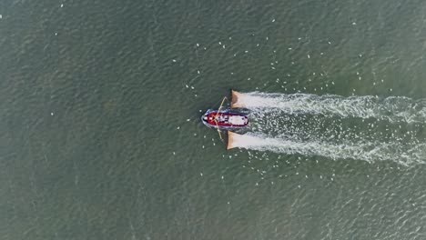 Drohnenaufnahme-Von-Oben-Eines-Fischerboots,-Das-Die-Netze-Durch-Das-Wasser-Zieht