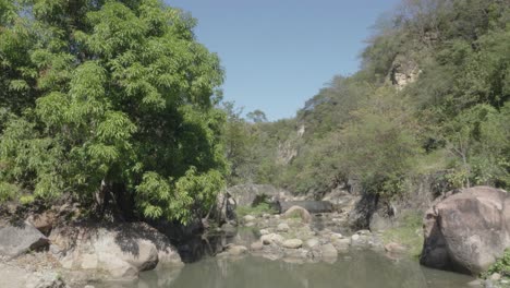 Aldeanos-Nadando-En-Una-Pequeña-Presa-De-Agua-En-El-Río-Rodeado-De-Muchas-Rocas-Y-árboles-Frondosos-En-Honduras
