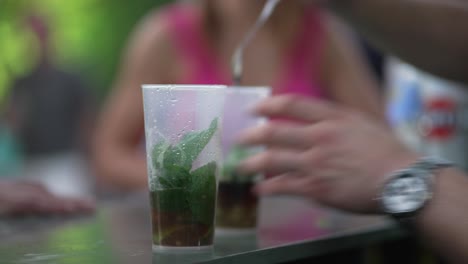 Stirring-a-minty-concoction-in-a-transparent-cup