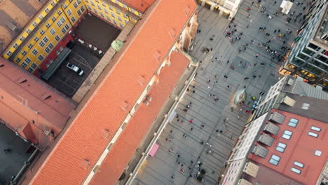 Top-down-view-aerial-shot-capturing-the-architectural-marvel-of-Munich's-Frauenkirche,-surrounded-by-the-vibrant-red-rooftops-of-the-city