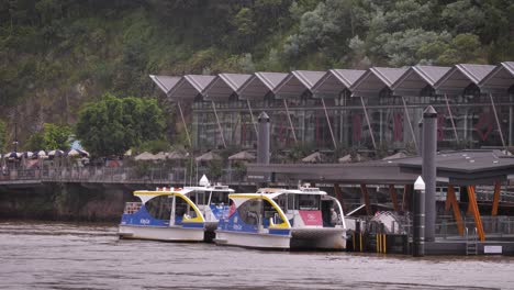 Dos-Pequeños-Ferrys-Esperando-En-Los-Muelles-De-Howard-Smith-Vistos-Desde-New-Farm-River-Walk