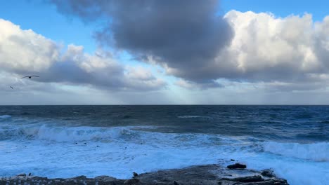 King-tide-at-La-Jolla-Cove-skyline-view-over-waves-crashing-on-clliffs-with-pellicans-flying-by