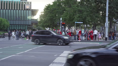 Grupo-De-Personas-Vestidas-Con-Trajes-De-Papá-Noel-Con-Scooters-Cruzando-Las-Calles-De-Melbourne,-Australia