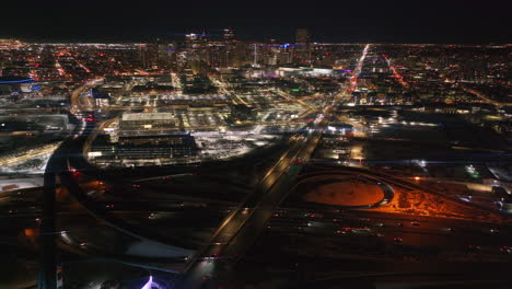Denver-downtown-i25-highway-traffic-aerial-drone-cinematic-anamorphic-snowy-winter-evening-dark-night-city-lights-landscape-Colorado-Mile-High-Pepsi-Center-Ball-arena-Broncos-forward-motion