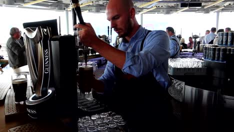 Bartender-serving-a-black-Guinness-beer-pint-at-Gravity-Bar-in-Dublin