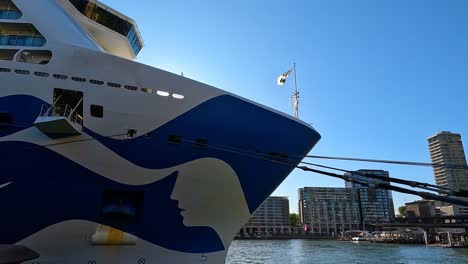 Bright-Sydney-skyline-with-modern-buildings-and-cruise-ship-under-blue-sky,-wide-angle