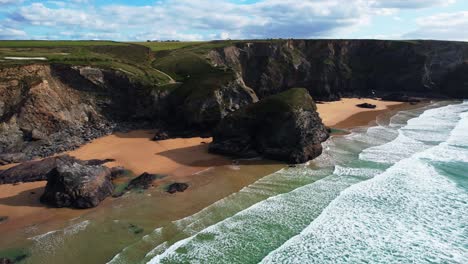 Bedruthan-Steps-Along-the-Cornish-Coastal-Path-with-Views-of-Beach-and-Ocean-Waves-from-an-Aerial-Drone