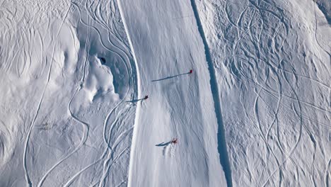 three-skiers-ride-down-a-beautiful-slope-and-blowing-up-snow-when-driving-curves-on-the-track