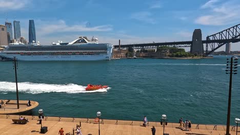 Sydney-Harbour-with-cruise-ship-and-speedboat,-sunny-day-with-clear-skies,-iconic-bridge-in-background,-wide-shot