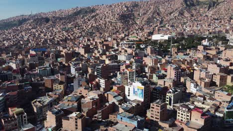 Aerial-slowly-rotates-over-mountain-city-skyline-of-Oruro,-Bolivia