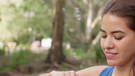 Close-up-slomo-tracking-shot-of-Catherine-blowing-bubbles-in-a-park