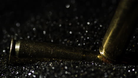 300-AAC-Blackout-Intermediate-Cartridge-Falling-Into-Pile-Over-Black-Bullet-Grains