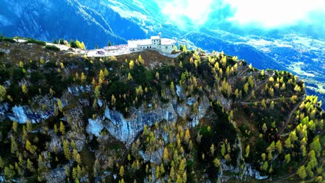 Aerial-view-of-winding-mountain-road-snaking-through-lush-green-valley