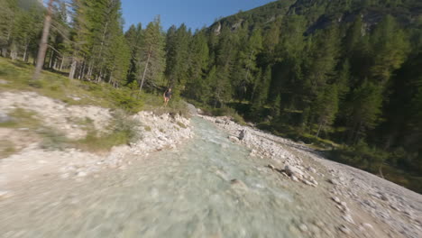 Drohne-FPV-Fliegt-Im-Sommer-über-Einen-Wasserstrom,-Der-Durch-Die-Berge-Fließt