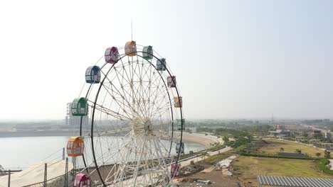 rajkot-atal-lake-drone-view-drone-camera-is-going-towards-the-side-and-big-giant-wheel-is-visible-many-gardens-are-also-visible-around,-Rajkot-New-Race-Course,-Atal-Sarovar