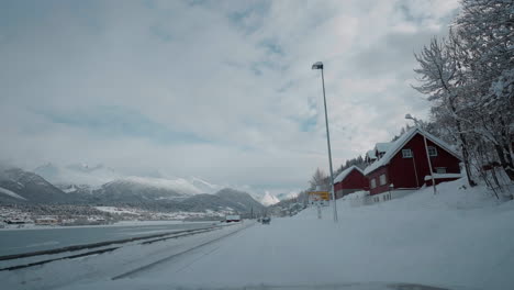 Vídeo-En-Primera-Persona-De-Un-Viaje-Diurno-Por-Las-Carreteras-Nevadas-De-Los-Fiordos-Occidentales-De-Noruega,-Rodeado-De-Altas-Montañas-Cubiertas-De-Nieve-Y-Con-árboles