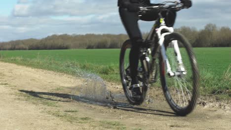 Ein-Mountainbiker-Fährt-Sein-Fahrrad-Unter-Einem-Klaren-Himmel-Mit-Wald-Im-Hintergrund-In-Frankreich